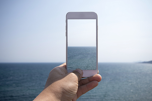스마트폰으로 바다를 찍는 모습