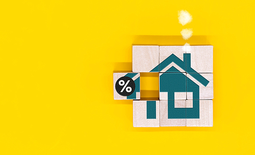 금리 금융 및 모기지 금리 개념. 트리 하우스와 퍼센트 아이콘이 있는 큐브 블록을 손에 넣습니다.