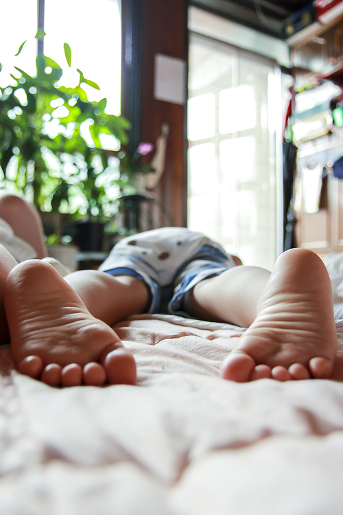 엎드려 예쁘게 잠들어 있는 아기의 발과 엉덩이사진