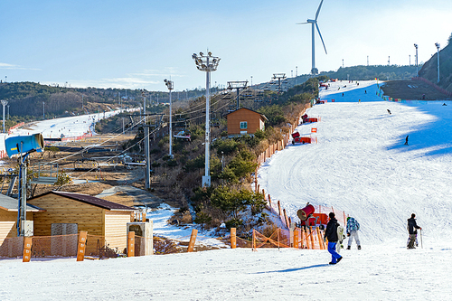 풍력 발전소 아래 짜릿한 스키 즐기는 스키어들