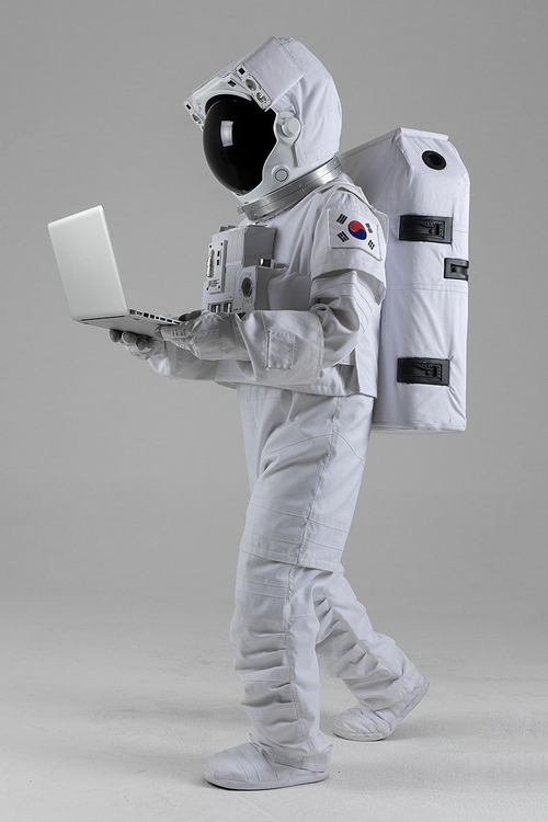 우주 생활 - 노트북을 보며 걸어가는 우주인