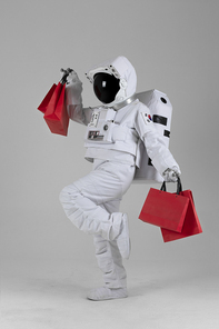 우주 생활 - 쇼핑백 들고 즐겁게 춤추는 우주인 옆모습 전신