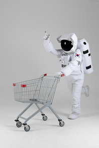 우주 생활 - 쇼핑카드 신나게 끌며 손가락으로 가리키는 우주인 전신