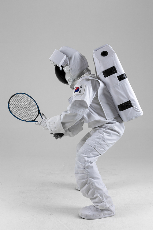 우주 생활 - 테니스 라켓을 들고 준비자세를 취하는 우주인 옆모습 전신