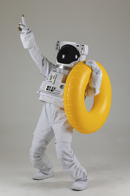 우주 생활 - 노란색 수영 튜브를 들고 손가락으로 가리키는 우주인 옆모습 전신