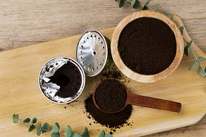제로웨이스트 - 나무 배경 위 나무 숟가락과 나무 그릇 그리고 캡슐 커피와 커피 찌꺼기들, 윗면