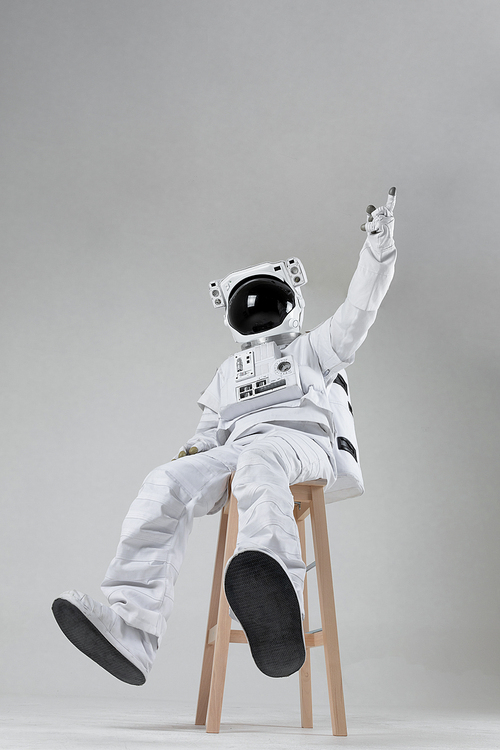 우주 생활 - 나무 의자에 앉아서 손가락으로 위를 가리키고 있는 우주인 앞모습
