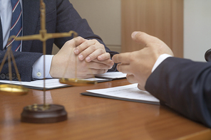 범죄와 법률 - 천칭 저울과 법률 상담을 하고 있는 법조인과 의뢰자의 손