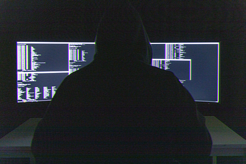 범죄와 법률 - 사이버 범죄를 저지르고 있는 해커의 뒷모습과 모니터
