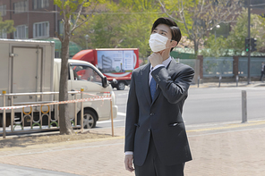 코로나 시대의 신입사원 - 미세먼지로 기침을 하고 있는 마스크 착용한 청년 신입사원