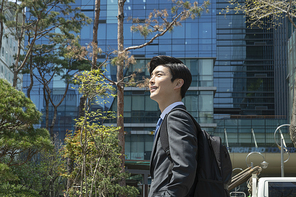 청년 신입사원의 하루 -  회사 건물을 바라보며 서있는 활기찬 청년 신입사원