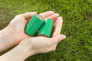 생활 속 에너지 - 잔디 배경, 두 손 위에 놓여진 큰 초록색 에코 건전지들