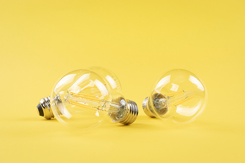 생활 속 에너지 - 노란색 배경지 위에 놓여진 투명한 전구들