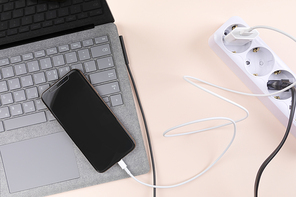 생활 속 에너지 - 핑크색 배경지 위에 놓여진 멀티 탭과 노트북, 스마트폰이 연결된 충전기들