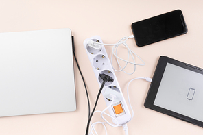 생활 속 에너지 - 핑크색 배경지 위에 놓여진 멀티 탭과 노트북, 스마트폰, 전자책이 연결된 충전기들
