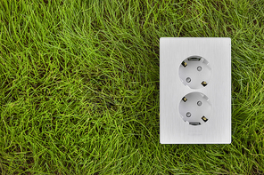 생활 속 에너지 - 푸른 잔디 위에 놓여진 콘센트 커버