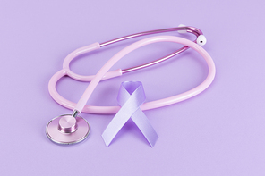 리본 - 연보라색 배경 위에 놓여있는 핑크색 청진기와 보라색 리본