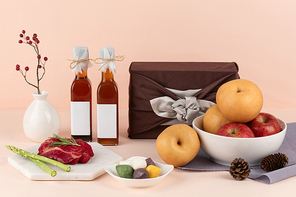 명절선물세트_사과와 배 과일들과 추석에 관련된 용품 및 송편과 고기 아스파라거스 그리고 보자기에 싸인 선물 정면 이미지  사진