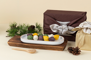 명절선물세트_송편이 담겨져 있는 그릇과 솔잎 솔방울 보자기에 싸인 상자와 갈대가 있는 정면 이미지 사진