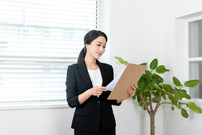 검은색 정장입은 여성이 차트 보고 있는 장면 이미지 사진
