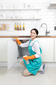 앞치마 입고 있는 여성이 고무장갑 착용하고 주방 청소 하는 장면 이미지 사진