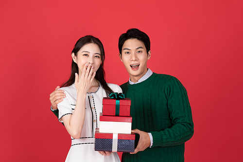 크리스마스 쇼핑이벤트 컨셉 커플이 밝게 웃으며 선물상자를 들고 있는 사진 이미지