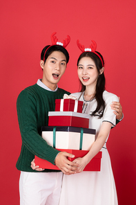 루돌프 머리띠 크리스마스 쇼핑이벤트 컨셉 커플이 선물상자들고 포즈 취하고 있는 사진