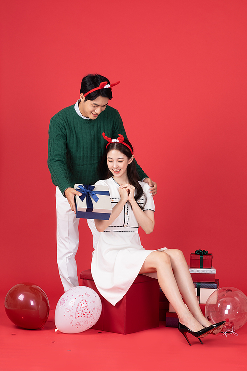 루돌프 머리띠 크리스마스 쇼핑이벤트 컨셉 커플이 선물상자 전달하는 사진