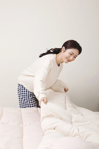 겨울실내일상_침대 정리하는 여성 사진