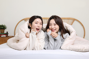 겨울실내일상_침대에서 이불덮고 있는 여성 2명 사진