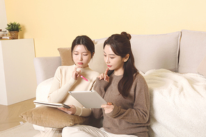 겨울실내일상_타블렛과 노트로 공부하고 있는 여성들 사진