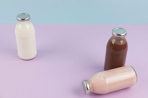 유제품_하늘색과 보라색 배경 병에 담긴 흰우유 딸기우유 초코우유 사진