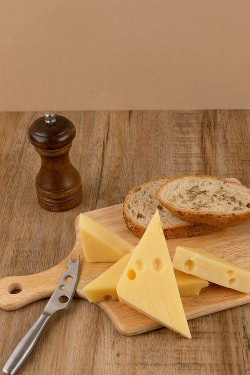 유제품_베이지색 갈색 나무 배경 에멘탈 치즈와 호밀빵 사진