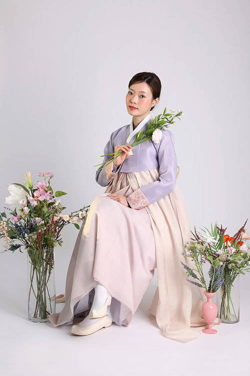 봄뷰티_한복입고 앉아 꽃들고 있는 여성 사진