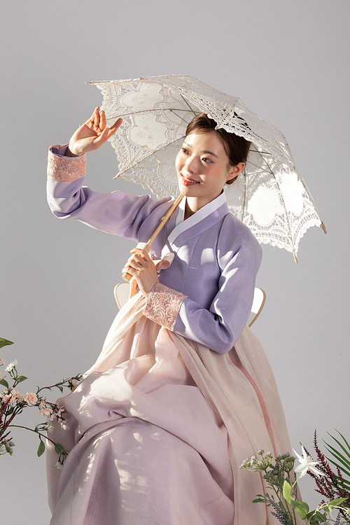 봄뷰티_한복입고 앉아 우산 들고 있는 여성 사진