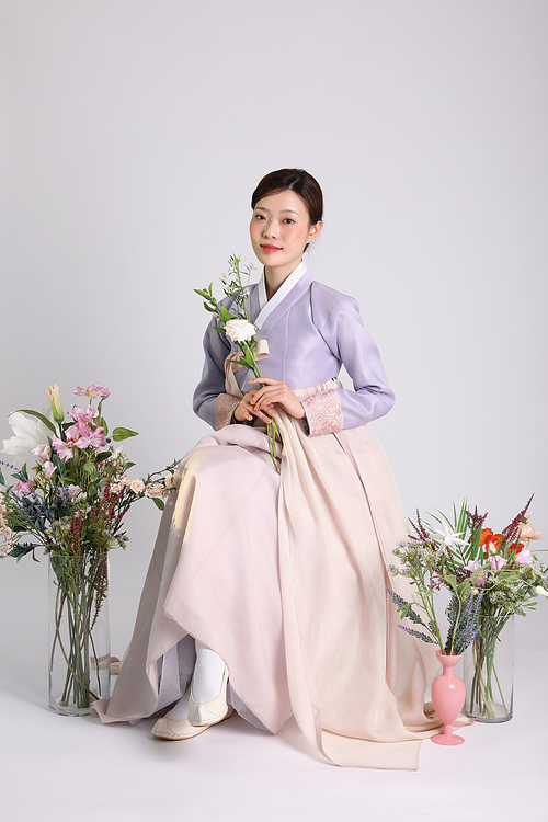 봄뷰티_한복입고 앉아 꽃들고 있는 여성 사진