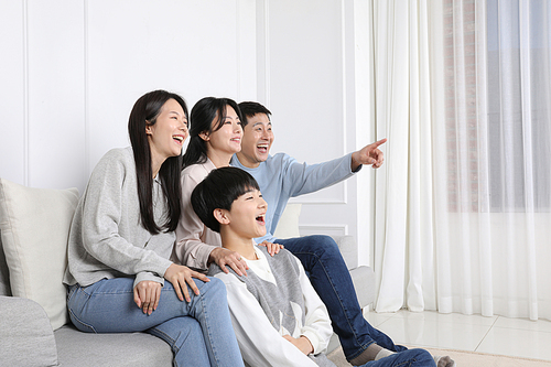 나의가족_재미있는 TV장면을 보고 웃고있는 가족 사진 이미지