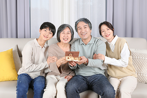 나의가족_조부모님과 손주들이 들고있는 주택모형 사진 이미지