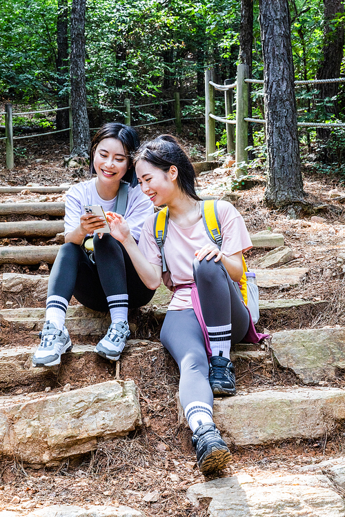 등산과플로깅_앉아서 스마트폰 보는 사진 이미지