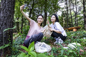 등산과플로깅_등산로에 쓰레기 정리하며 촬영하는 사진 이미지