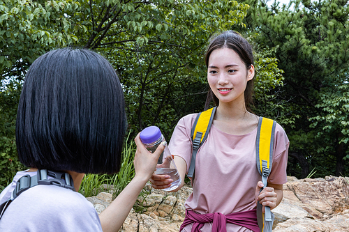 등산과플로깅_물병 건내주는 사진 이미지