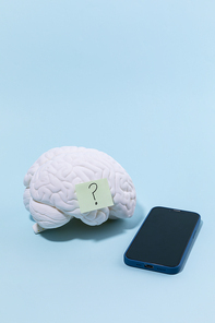 뇌건강과치매_물음표가 붙여져 있는 뇌모형과 핸드폰 사진 이미지