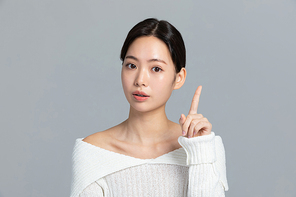 윈터뷰티_미소 지으며 손동작하는 여성 사진 이미지