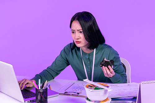 비즈니스_컵라면과 삼각김밥 먹으며 업무에 집중하고 있는 청년 사진 이미지