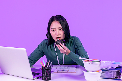 비즈니스_컵라면과 삼각김밥 먹으며 업무에 집중하고 있는 청년 사진 이미지