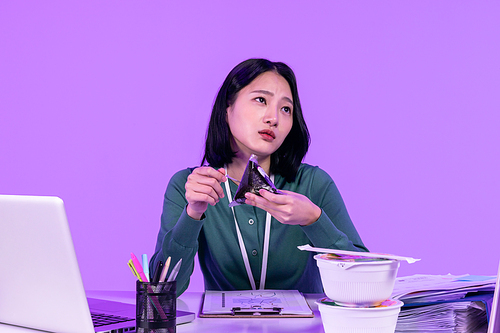 비즈니스_컵라면과 삼각김밥 먹으며 일에 지친 청년 사진 이미지