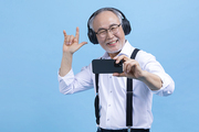 힙노년_헤드셋 끼고 핸드폰 보는 시니어 사진 이미지