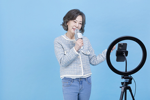 힙노년_핸드폰 보며 노래 부르는 시니어 사진 이미지