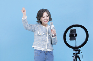 힙노년_핸드폰 보며 노래 부르는 시니어 사진 이미지