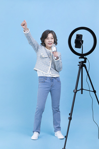 힙노년_핸드폰 보며 노래 부르는 시니어 사진 이미지